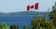 Bandera canadiense ondeando sobre un cuerpo de agua. Canadá del este. Este de Canada. Viajes, viaje, viajar.